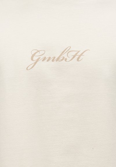 Ύφασμα εκρού με τη λέξη «GmbH» τυπωμένη σε ανοιχτό καφέ καλλιγραφική γραφή στο κέντρο της επιφάνειας.
