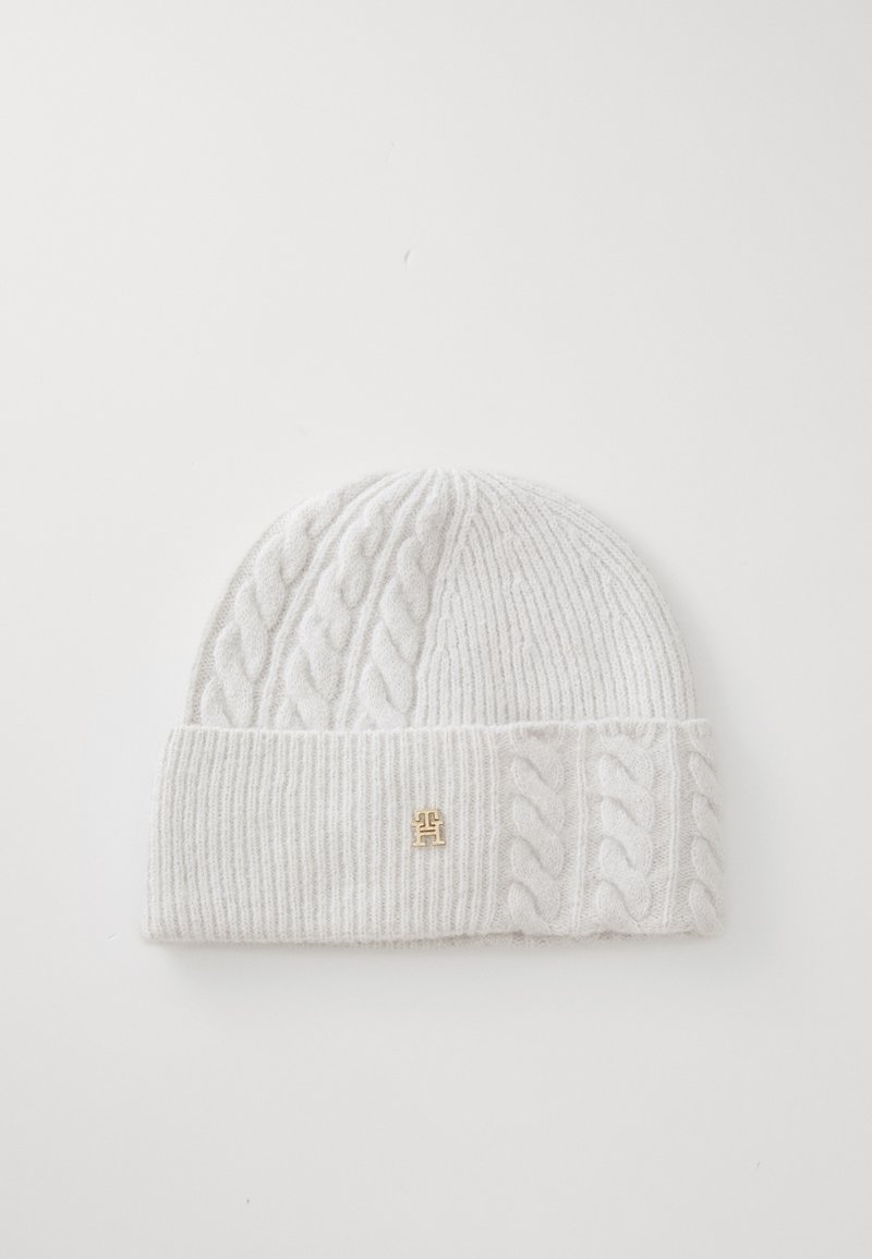 Gorro de malha em material branco suave, apresentando um design em canelado e malha de cabos. Inclui um destaque com logótipo dourado na bainha dobrada.