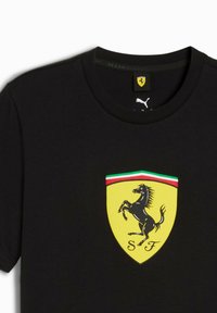 Sort t-shirt med Ferrari-logoen, en rejsende sort hest på et gult skjold med en grøn og rød stribe øverst.
