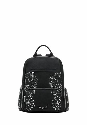 Mochila negra con patrones florales blancos con tachuelas, bolsillos frontales y laterales con cremallera y asa superior.
