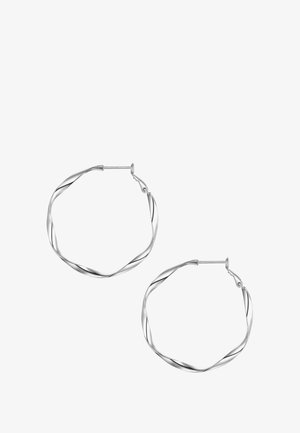 Suknje iz zavite srebrne žice z gladko, odsevno površino in varnim zaklepom. Premer približno 3 cm.