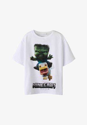Biały bawełniany T-shirt z nadrukiem graficznym zielonej postaci i kaczki oraz napisem „A Minecraft Movie” poniżej. Krótkie rękawy, luźny fason.