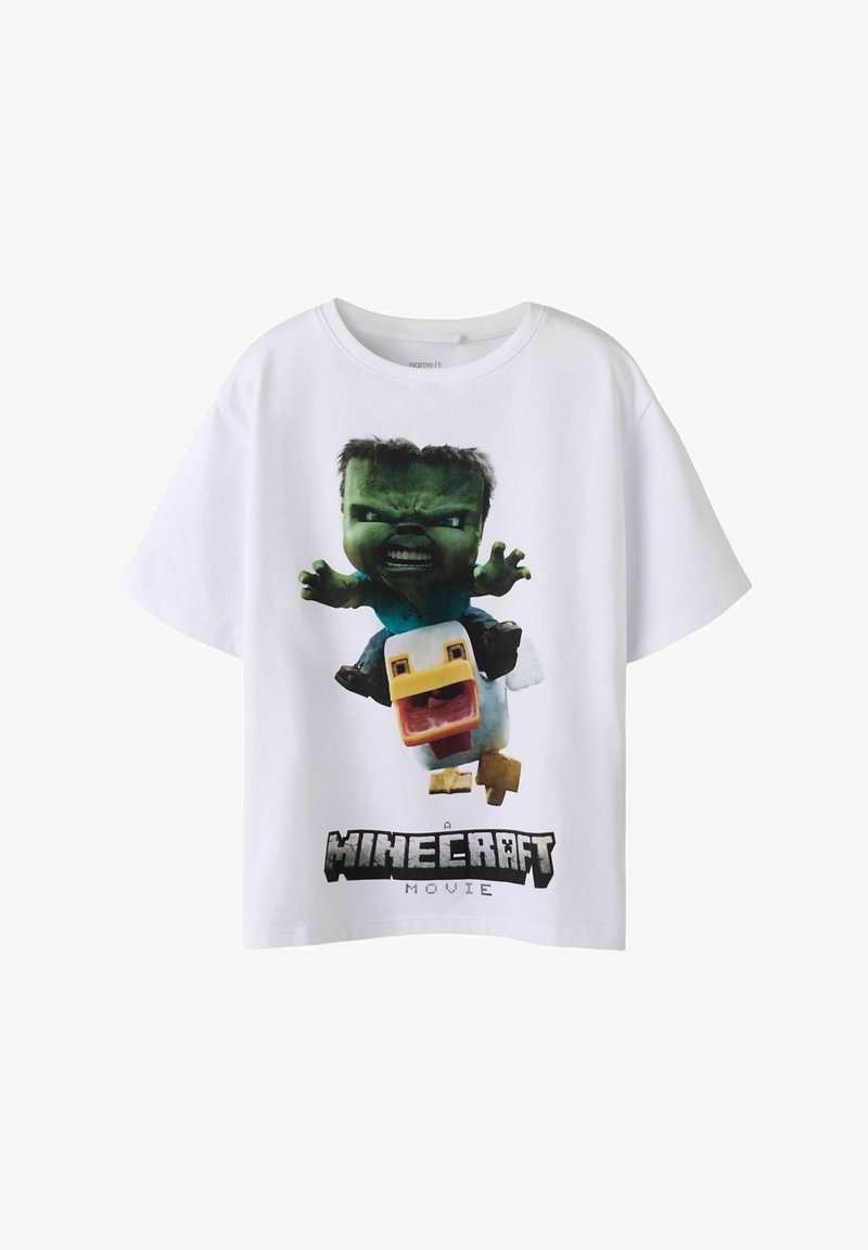 Biały bawełniany T-shirt z nadrukiem graficznym zielonej postaci i kaczki oraz napisem „A Minecraft Movie” poniżej. Krótkie rękawy, luźny fason.
