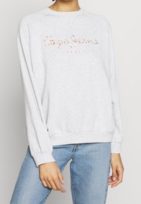 Felpa grigia con scollo tondo e maniche lunghe, caratterizzata da un testo ricamato colorato "Pepe Jeans LONDON" sul davanti.