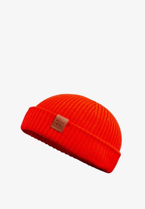 Red knit beanie with a ribbed texture, featuring a leather logo patch on the front. The design is snug and rounded at the top.
