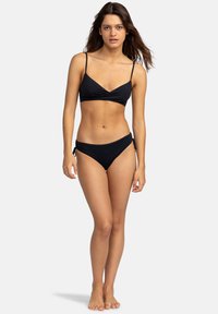Černý bikini set obsahující top vázaný kolem s tenkými ramínky a odpovídající spodní díl s nízkým pasem a nastavitelnými bočními tkaničkami. Hladký, elastický materiál.