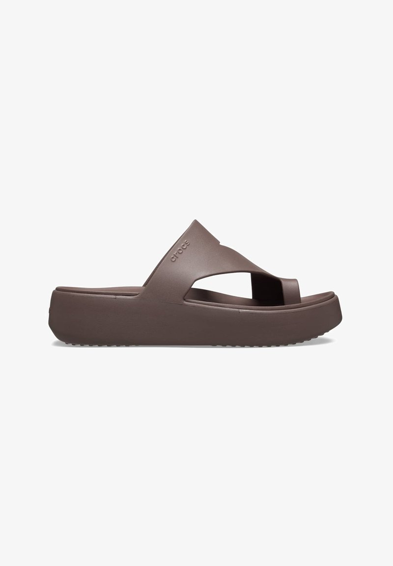 Braune Plattform-Sandalen aus Gummi mit Kreuzriemen-Design, offenen Zehen und strukturiertem Sohlenprofil für besseren Halt. Logo an der Seite.