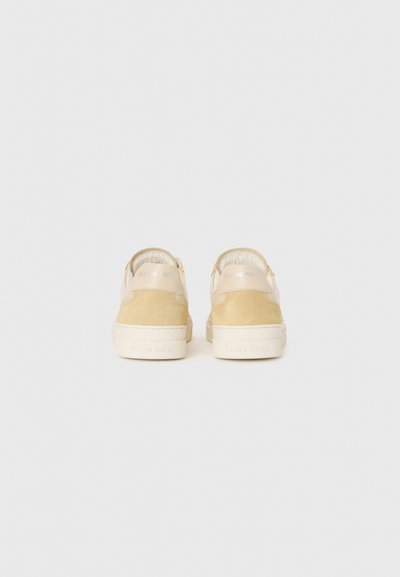 Beige nubuk- ja nahkkingad nähtud tagantpoolt "Filling Pieces" brändimisega kontsadeks ja vaheosadeks.