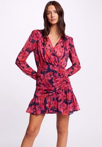 Floral wrap dress featuring a navy background with pink and red flowers, puffed long sleeves, a ruched waist, and a flared ruffled hem.