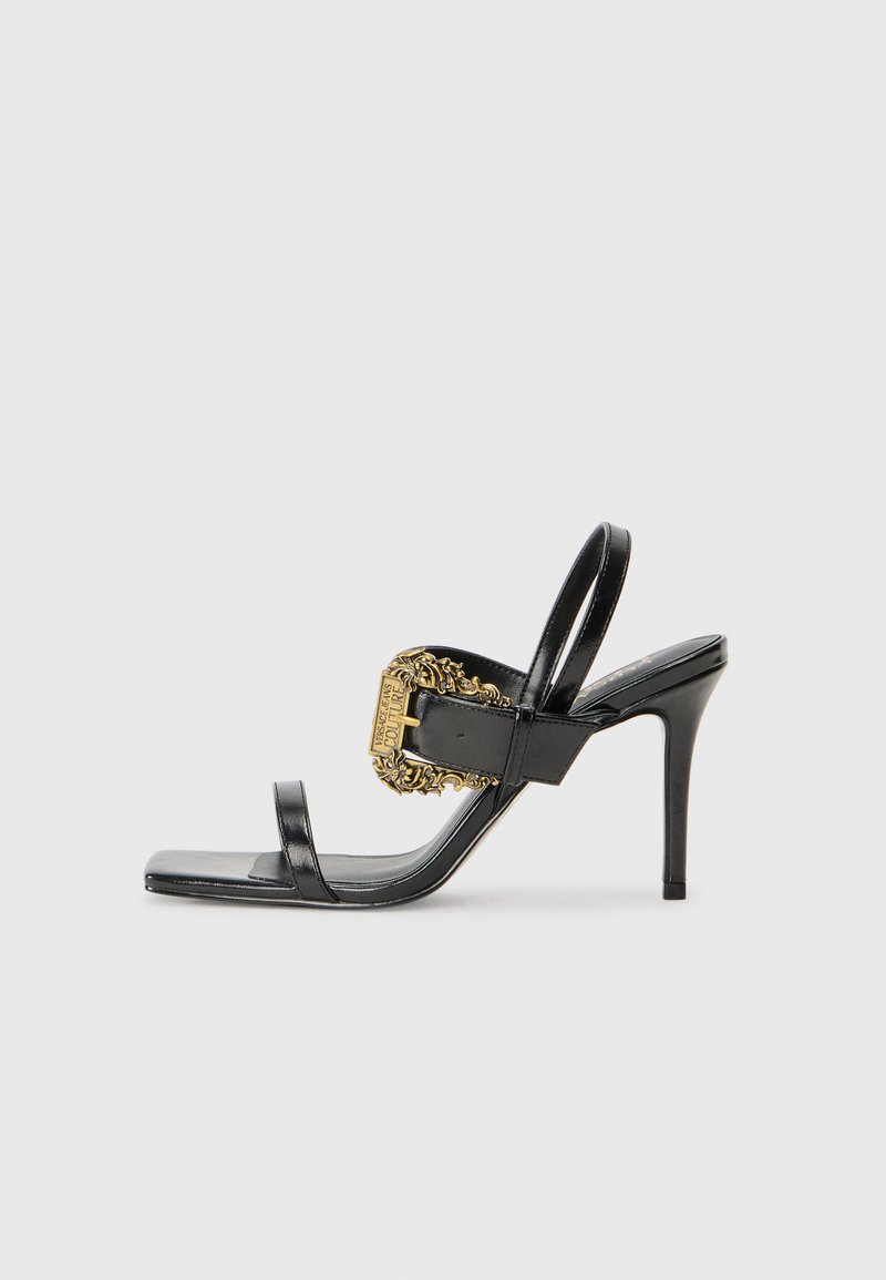 Black leather high-heeled sandals featuring a square toe, two thin straps, and a decorative gold buckle with ornate detailing on the side.