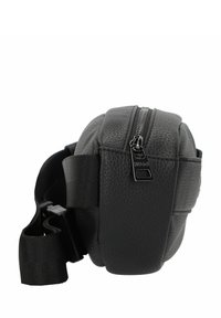 Borsa in pelle nera con texture, dalla forma arrotondata, chiusura con zip e tracolla in tessuto regolabile. Presenta un logo e un cursore della zip liscio.