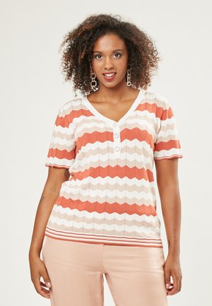 Korte mouwen gebreid top met een zigzagpatroon in tinten oranje, crèmekleurig en beige. V-halslijn met drie knopen en geribbelde afwerking.