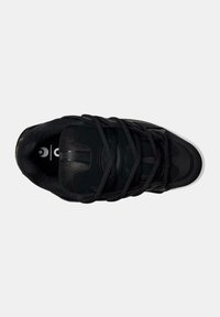 Scarpa sportiva nera con una parte superiore testurizzata, dotata di lacci, punta arrotondata e suola bianca. Include dettagli del logo sulla soletta.