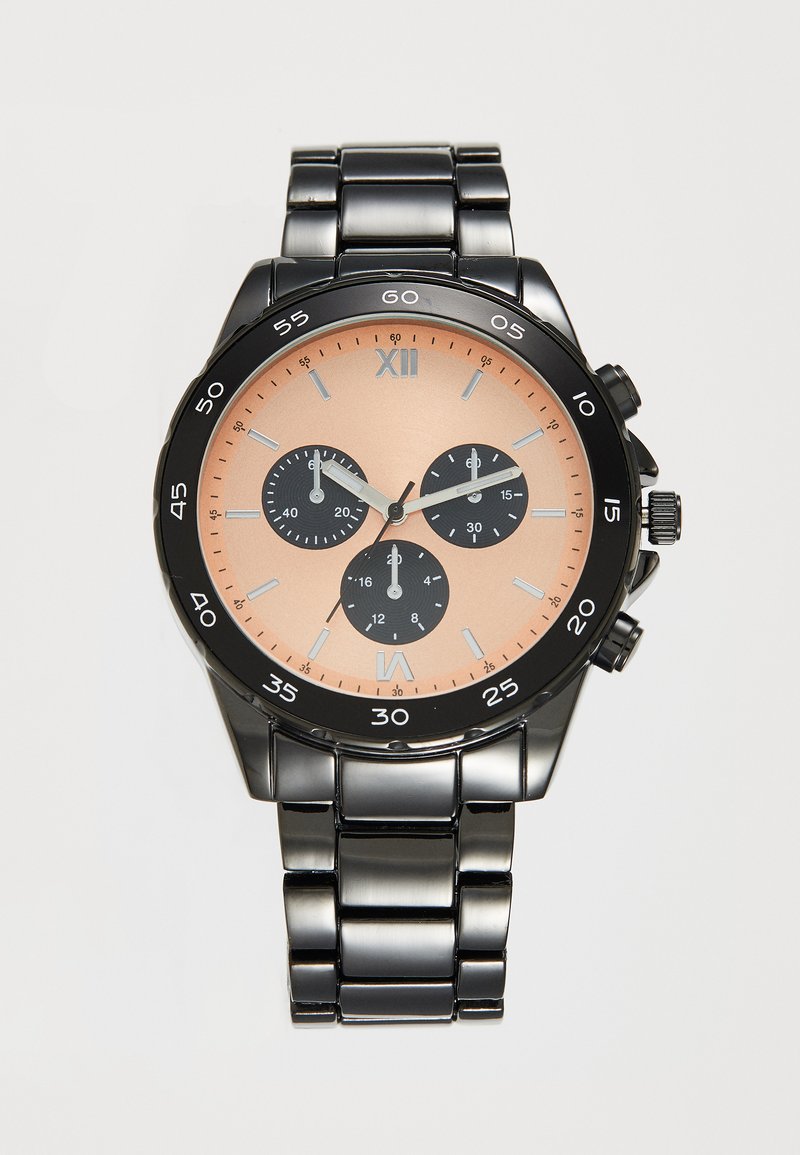 Montre chronographe avec un bracelet en métal noir, un boîtier rond et un cadran pêche avec trois sous-cadrans noirs. Aiguilles des heures et des minutes en argent.