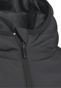 Zbliżenie na czarną kurtkę puchową z kołnierzem, pół-zamkiem i materiałowym klapkiem zakrywającym górną część zamka.