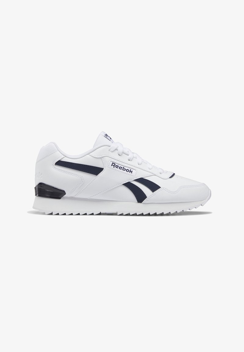 Baskets blanches Reebok avec des bandes noires latérales, lacets à l'avant, languette avec logo et semelle dentelée, présentées en profil latéral sur fond blanc.