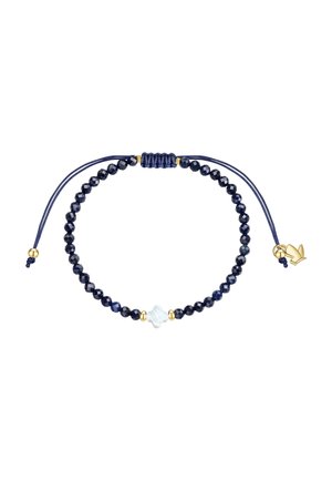 Verstelbare armband met donkerblauwe facetgeslepen kralen, een witte bloemvormige kraal in het midden en kleine gouden accenten op een witte achtergrond.