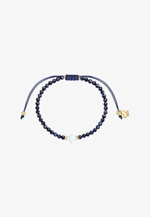 Justerbart armbånd med mørkeblå fasetterede perler, en hvid blomstformet perle i midten og små guld accenter på en hvid baggrund.