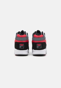 Zapatillas altas con un upper de ante negro y sintético rojo, acentos grises, suelas blancas y un parche con el logo en el talón.