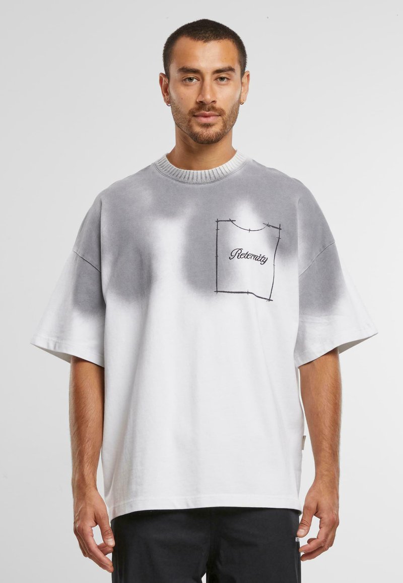 Grå-hvit oversized T-skjorte med gradientfarge, rund hals og sydd lomme, med teksten "Eternity" i dekorativ skrift.