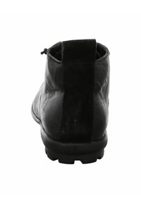 Zwarte leren enkelboot met een suède rugpaneel, ronde neus en gestructureerde zool voor grip. Minimalistisch ontwerp zonder zichtbare bevestigingen.