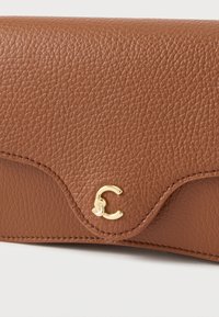 Portafoglio in pelle marrone con finitura testurizzata, caratterizzato da una patta curva e un logo dorato. Cuciture evidenti lungo i bordi.