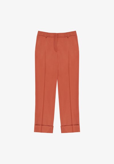 Pantaloni di colore ruggine con una vestibilità sartoriale, caratterizzati da doppie pieghe, una texture liscia e orli a fondo per un aspetto strutturato.
