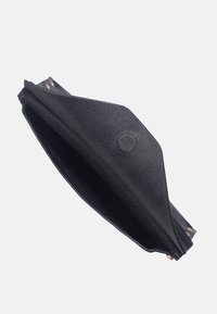 Svart läderkuvert med en strukturerad yta, triangulär form och detaljer i guld. Öppen design som avslöjar ett rymligt inre.