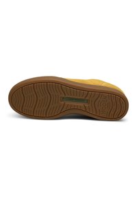 Shoe with a yellow suede upper and a brown rubber outsole. Features a textured sole for grip, minimal branding, and a sleek design.