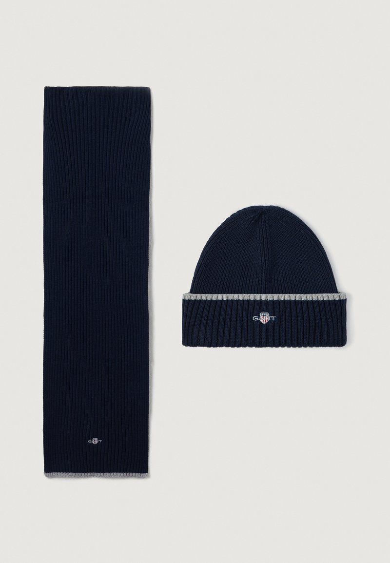 Set di sciarpa e berretto lavorati a maglia di colore blu navy con una texture a coste, con un accento a strisce grigie sul berretto e un dettaglio logo.