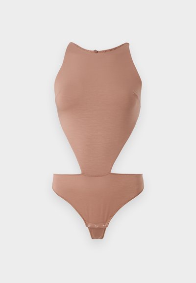 Nude bodysuit made of smooth, stretchy fabric. Features a high neckline, sleeveless design, and mid-thigh cut with snap closures.