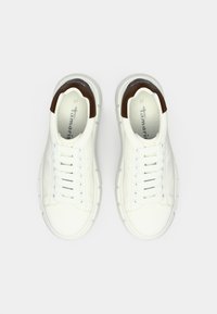 Λευκά δερμάτινα αθλητικά παπούτσια με υφή, με καφέ λεπτομέρεια στη φτέρνα, έξι τρύπες για κορδόνια και χοντρή λευκή σόλα. Μέγεθος 37.