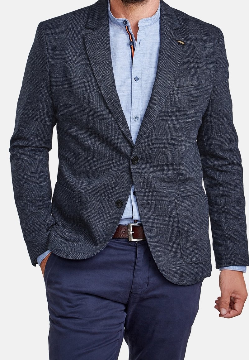 Marinblazer med subtilt rutig mönster, utrustad med två framfickor, en knappstängning och en bröstficka.