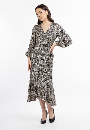 Robe portefeuille à imprimé léopard avec un décolleté en V, des manches ballons longues et un ourlet volanté, fabriquée en tissu lisse. Assortie à des talons noirs.