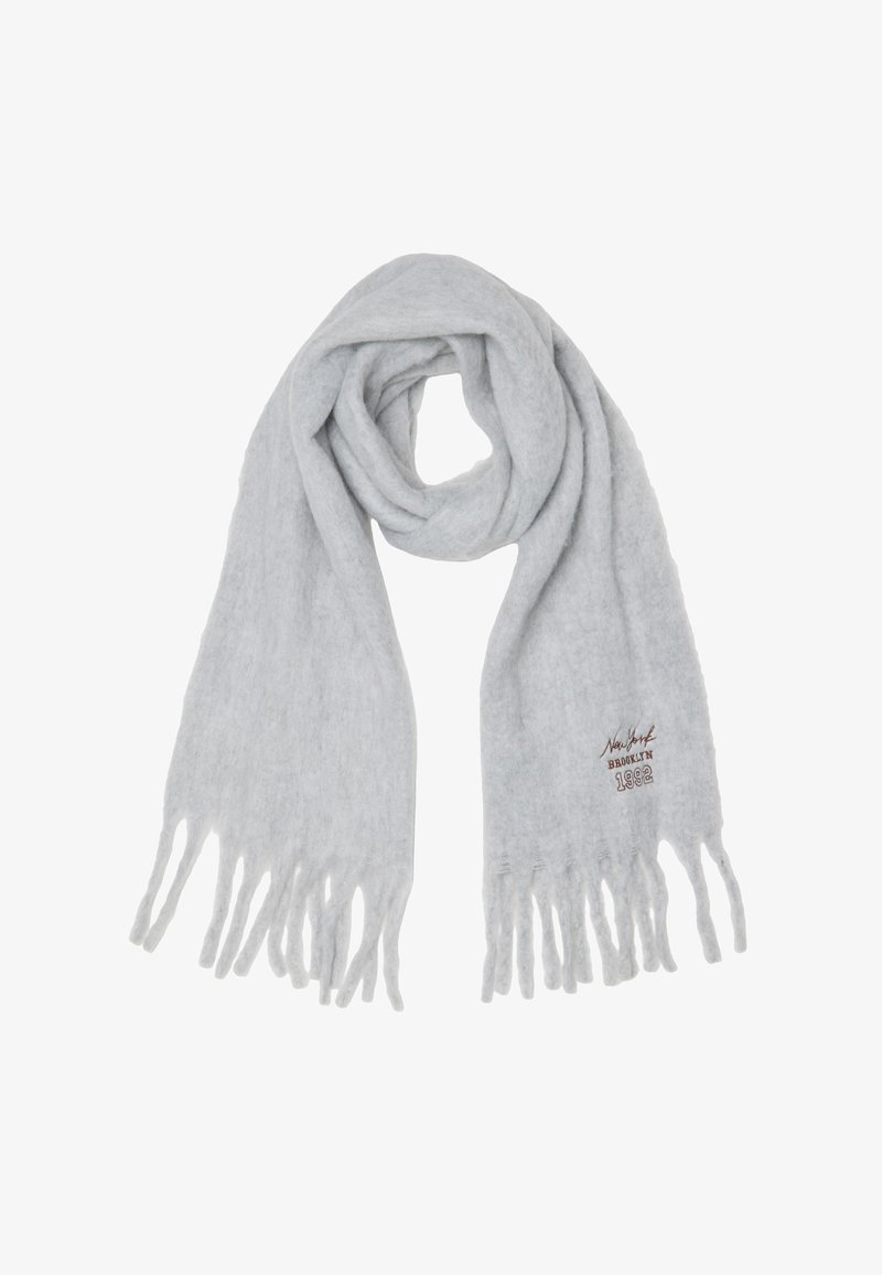 Sciarpa lavorata a maglia grigia chiara con frange alle estremità. Presenta un ricamo in marrone con la scritta "New York BROOKLYN 1982."