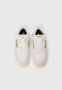 Et par hvite og gule sneakers med snørebånd, sett ovenfra på en enkel hvit bakgrunn.