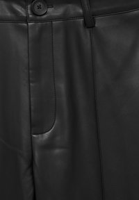 Pantalon en cuir noir avec une texture lisse, une poche avant et une fermeture à bouton unique. Détails de coutures le long des coutures.