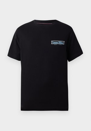 Czarny bawełniany t-shirt z krótkimi rękawami, z niebiesko-białym logo "Tommy Hilfiger" na lewej części klatki piersiowej. Klasyczny krój z okrągłym dekoltem.