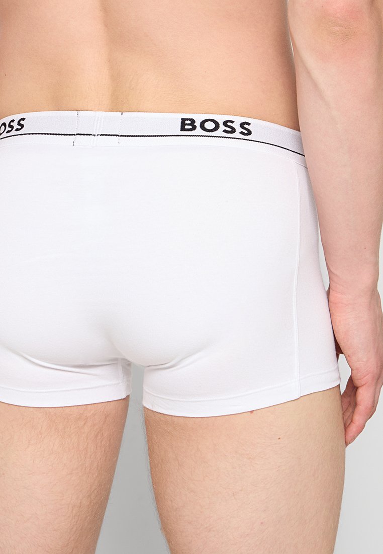 Boxer briefs blancos con un diseño ajustado, que cuentan con una cinturilla de logotipo negro y textura suave, que se extienden hasta la mitad del muslo.