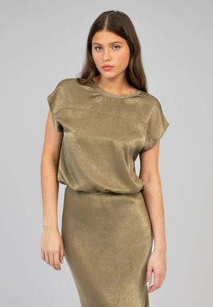 Haut olive, à manches courtes, avec une texture lisse et brillante et un col arrondi, associé à une jupe moulante assortie.