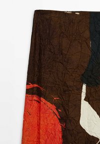 Tessuto stropicciato che mostra una base marrone con motivi astratti in rosso e bianco, caratterizzato da texture distinte e contrasti di colore.