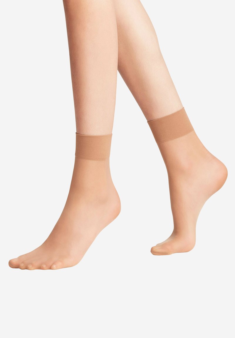 Nackte Knöchelsocken mit einer glatten, transparenten Textur und einem festen, weichen Gummiband an der Oberseite, das einen bequemen, tief ausgeschnittenen Sitz bietet.