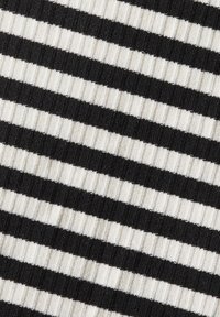 Tissu côtelé noir et blanc avec des rayures horizontales alternées créant un motif texturé.