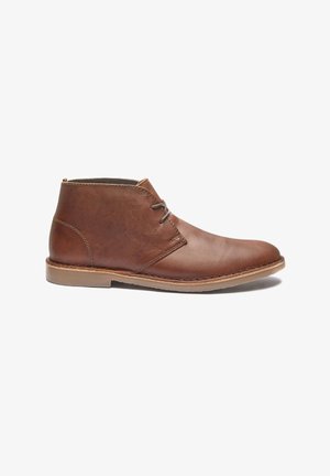 Bottines en cuir marron avec un design élégant, dotées d'un lacet simple, d'un bout arrondi et d'une semelle en caoutchouc. Texture lisse avec des accents cousus.