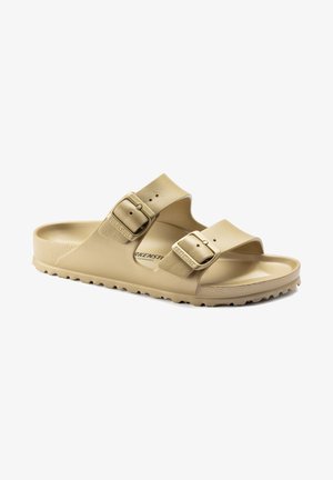 Light beige slide sandal with two adjustable buckled straps, textured upper, and a molded footbed. Features a durable rubber outsole with ridges.