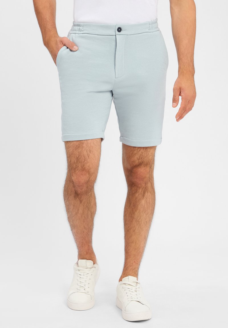 Lichtblauwe shorts van zachte stof, met een elastische tailleband, een knoop aan de voorkant, zijzakken en opgerolde mouwen.