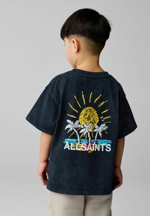 Laps, kellel on lühikesed tumedad juuksed, kannab musta t-särki, millel on kollane päike, valged palmipuud, sinine vesi ja seljal tekst "ALLSAINTS".