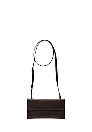 Borsa a tracolla in pelle nera con tracolla sottile regolabile e chiusura con patta pieghevole, mostrata su sfondo bianco.