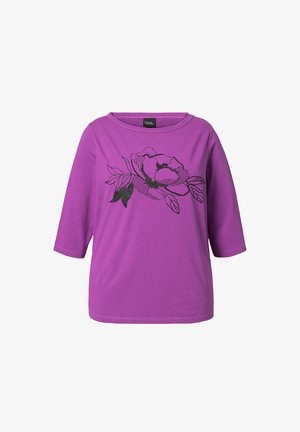 Fioletowa koszula o długości trzy czwarte z kwiatowym wzorem w kolorze czarnym. Wykonana z miękkiego materiału, z okrągłym dekoltem i luźnym fasonem.