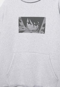 Grå sweatshirt med et sort-hvidt billede af en karakters ansigt i midten. Indeholder en frontlomme og ribstrikkede manchetter.